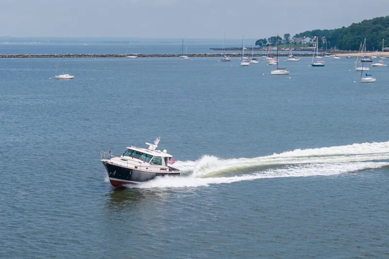 Slide: The Image of 2024 Sabre 43 Salon Express cruising on a scenic bay with sailboats in the background. - 20