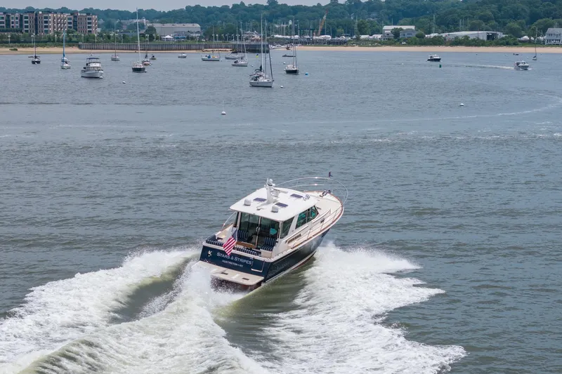 Slide: The Image of 2024 Sabre 43 Salon Express cruising on a scenic waterway with other boats. - 21