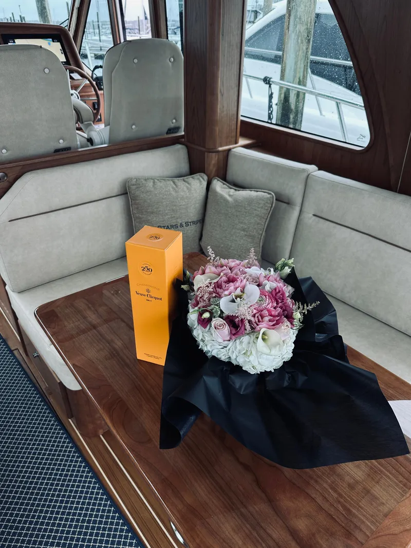 Slide: The Image of 2024 Sabre 43 Salon Express interior with flowers and champagne on a wooden table. - 34