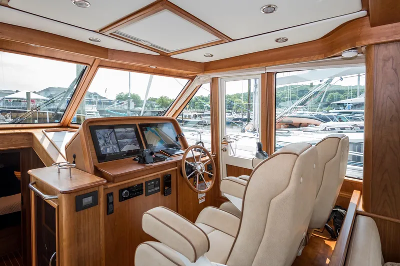 Slide: The Image of 2024 Sabre 43 Salon Express interior with helm, navigation screens, and luxurious seating. - 42