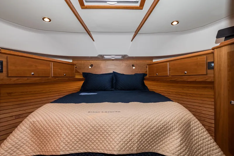 Slide: The Image of Luxurious cabin interior of 2024 Sabre 43 Salon Express with wood paneling and cozy bedding. - 44
