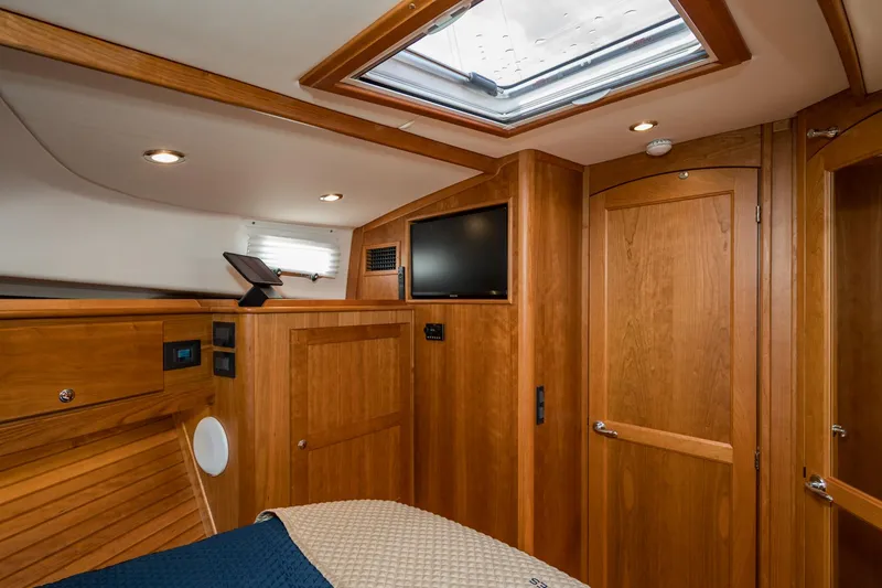 Slide: The Image of 2024 Sabre 43 Salon Express interior with wood finish, skylight, and TV. - 46