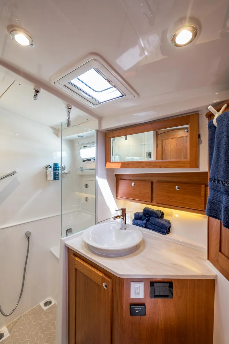 Slide: The Image of 2024 Sabre 43 Salon Express bathroom with modern fixtures and wooden cabinetry. - 48