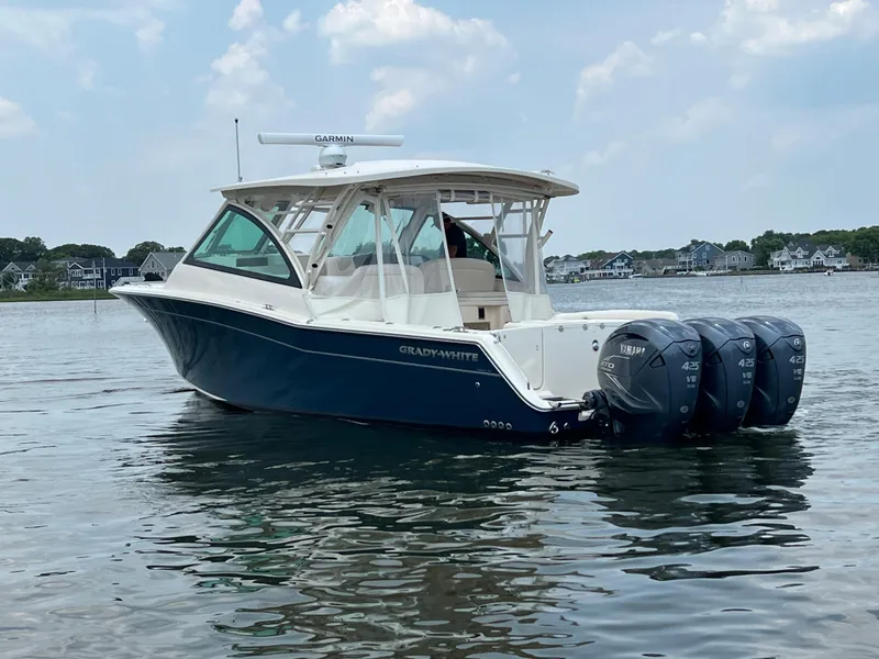 Slide: The Image of 2020 Grady-White Freedom 375 boat on calm water with triple outboard engines. - 14