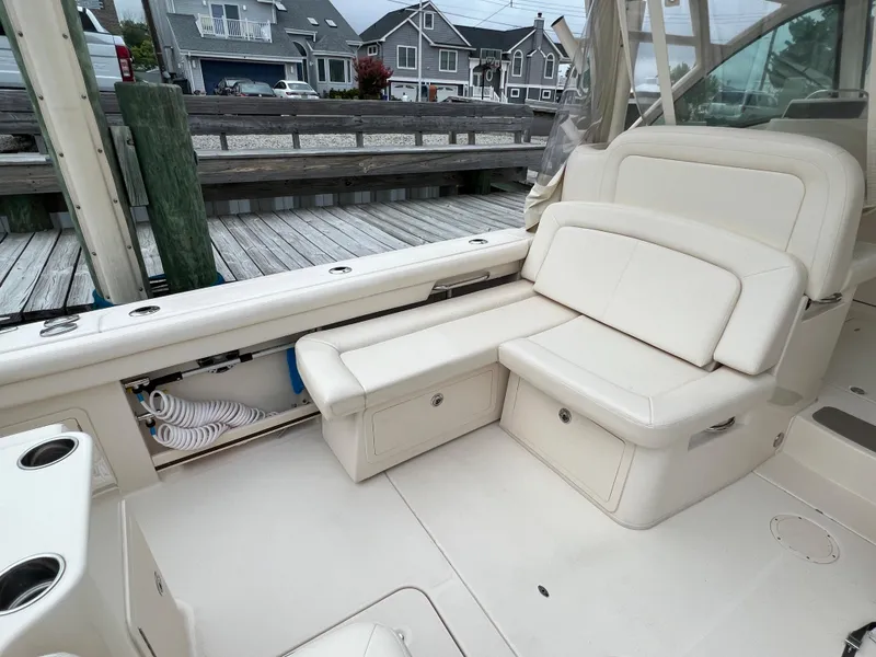 Slide: The Image of 2020 Grady-White Freedom 375 boat interior with white seating and dockside view. - 26