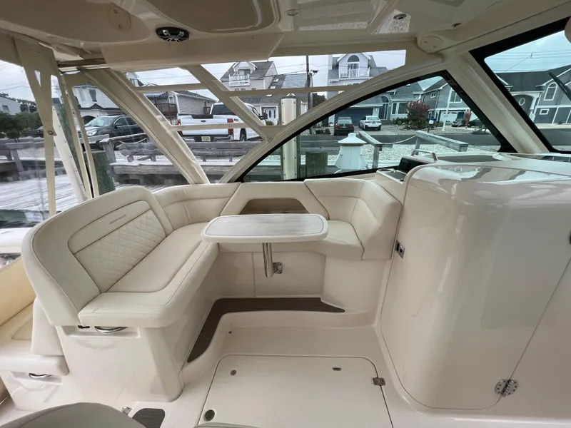 Slide: The Image of 2020 Grady-White Freedom 375 boat interior with white seating and table, docked at marina. - 29