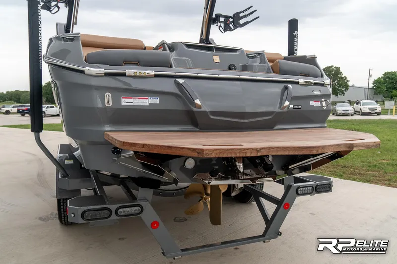 Slide: The Image of 2025 MasterCraft X22 boat rear view with teak swim platform and propeller. - 12