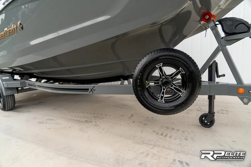 Slide: The Image of 2025 MasterCraft X22 boat on trailer, showcasing sleek design and modern features. - 19