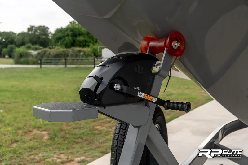 Slide: The Image of 2025 MasterCraft X22 boat trailer with winch and roller, parked outdoors. - 22