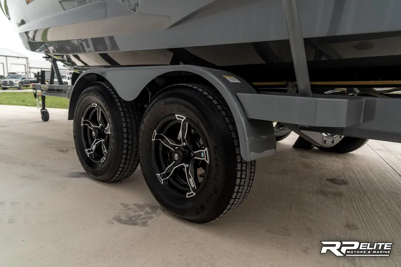 Slide: The Image of 2025 MasterCraft X22 boat trailer with sleek black wheels. - 28