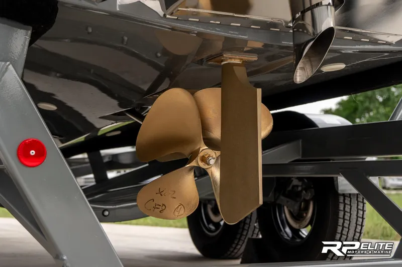 Slide: The Image of 2025 MasterCraft X22 boat propeller and rudder detail on trailer. - 31