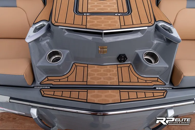 Slide: The Image of 2025 MasterCraft X22 boat interior with tan and gray seating, cup holders, and teak-style flooring. - 41