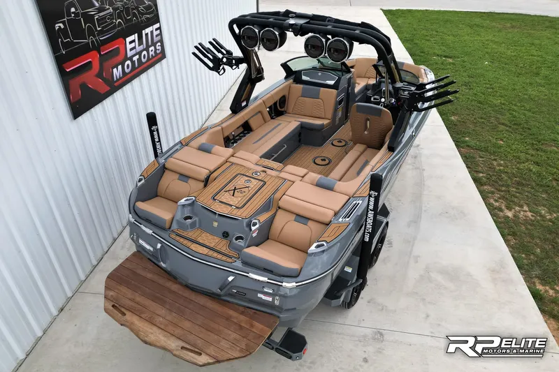 Slide: The Image of 2025 MasterCraft X22 boat with tan seating and advanced audio system at RP Elite Motors. - 5