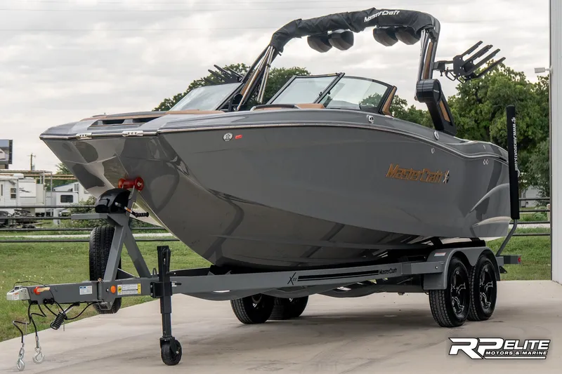 Slide: The Image of 2025 MasterCraft X22 boat on trailer, sleek design, gray color, parked outdoors. - 9
