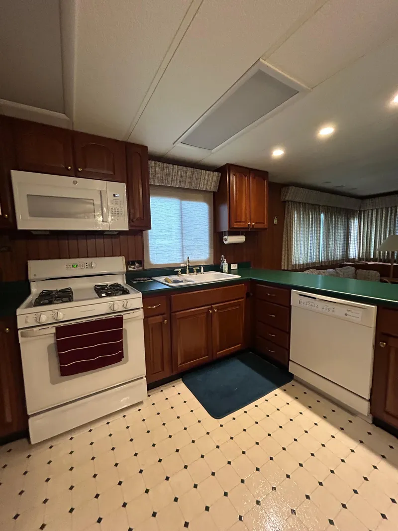 Slide: The Image of Kitchen interior of a 2001 Jamestowner houseboat with appliances and wooden cabinetry. - 13