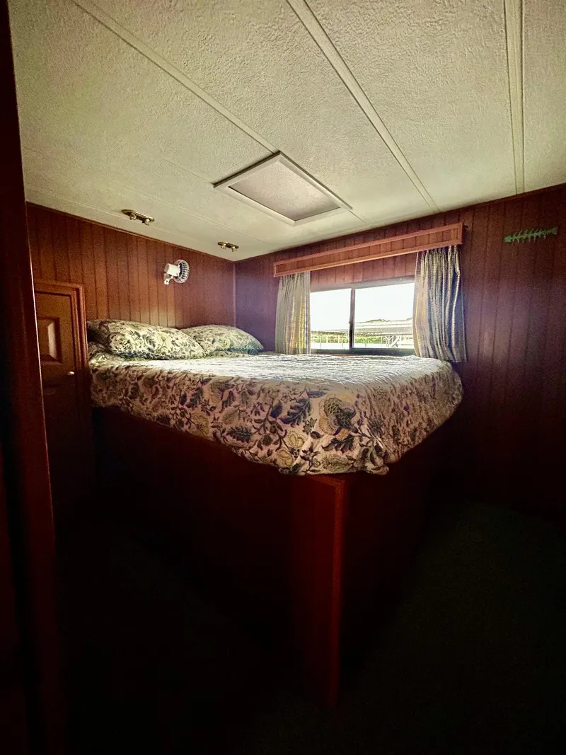 Slide: The Image of Cozy bedroom in 2001 Jamestowner houseboat with wood paneling and floral bedding. - 14