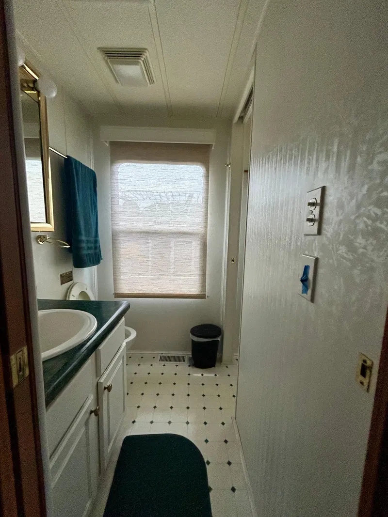Slide: The Image of 2001 Jamestowner houseboat bathroom with sink, window, and green accents. - 15
