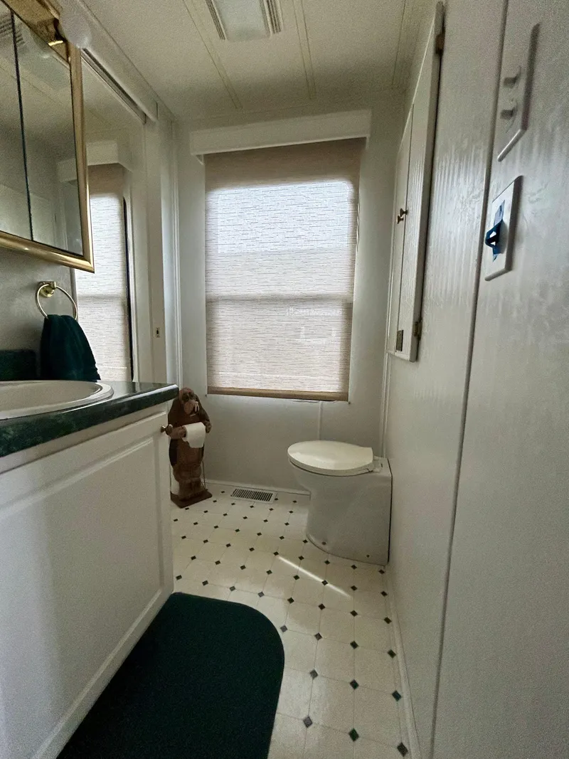 Slide: The Image of Bathroom interior of 2001 Jamestowner houseboat with white fixtures and green accents. - 17