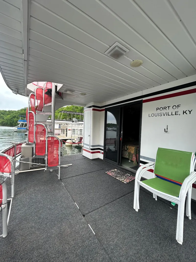 Slide: The Image of 2001 Jamestowner houseboat deck at Port of Louisville, KY, with red spiral staircase and green chair. - 23