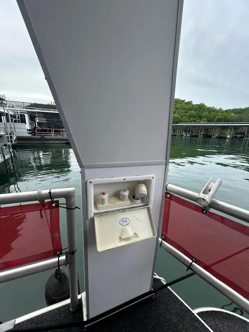 Slide: The Image of 2001 Jamestowner houseboat deck with utility panel, docked on a serene lake. - 24