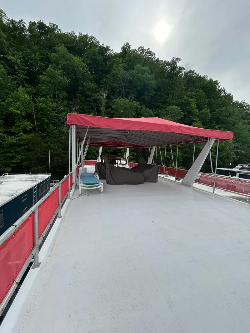 Slide: The Image of 2001 Jamestowner houseboat with red canopy, spacious deck, and forested backdrop. - 25