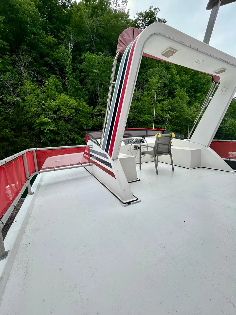 Slide: The Image of 2001 Jamestowner houseboat deck with seating, surrounded by lush greenery. - 26