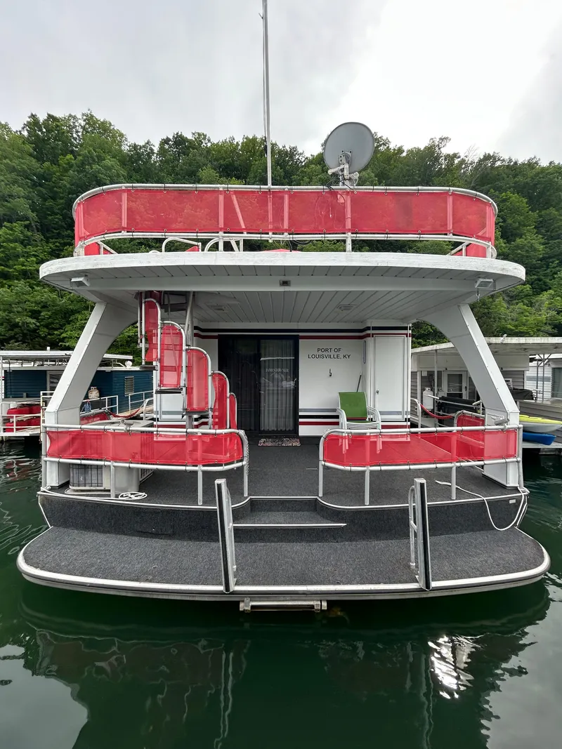 Slide: The Image of 2001 Jamestowner houseboat with red accents, docked on a calm lake. - 27