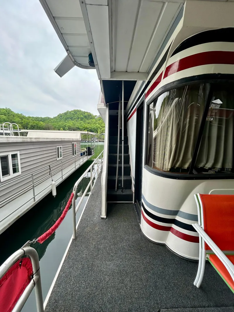 Slide: The Image of 2001 Jamestowner houseboat deck with seating, docked beside another boat. - 5