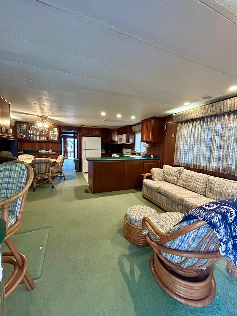 Slide: The Image of Interior of a 2001 Jamestowner houseboat with cozy seating and kitchen area. - 6