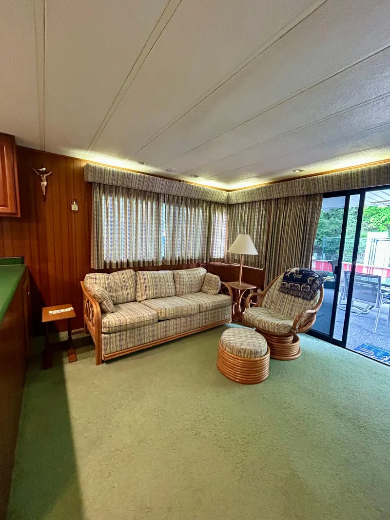 Slide: The Image of Cozy 2001 Jamestowner houseboat interior with sofa, chair, and sliding glass door. - 7
