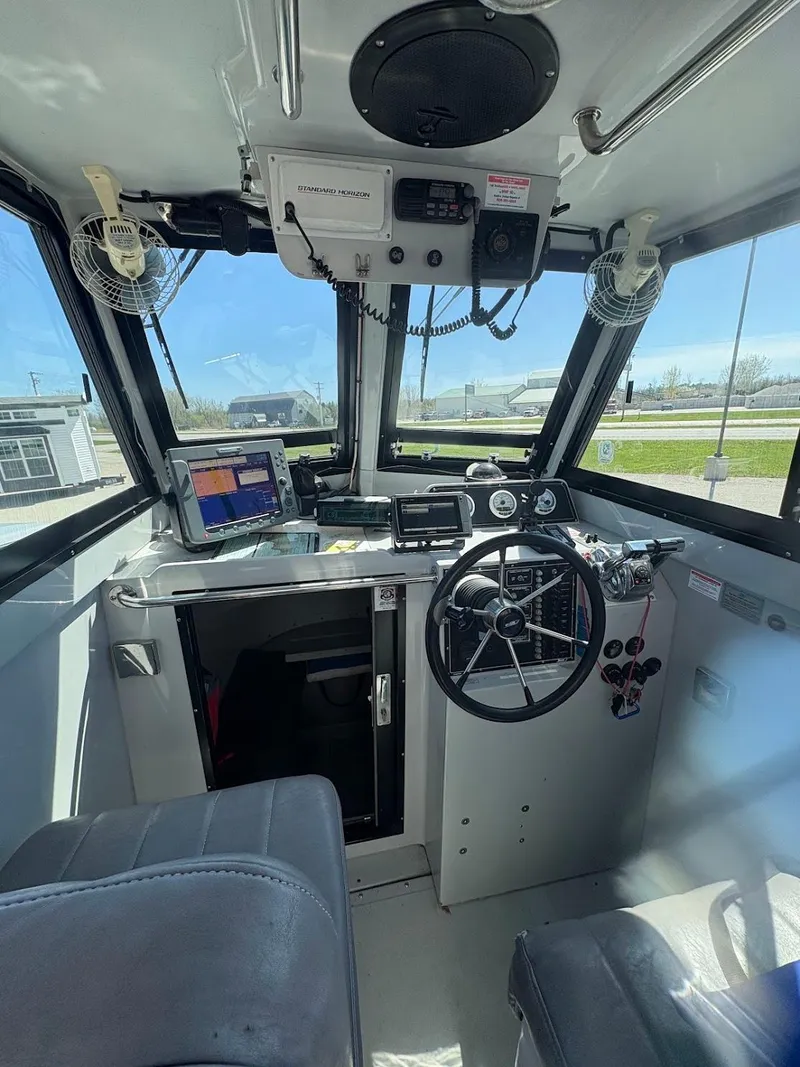Slide: The Image of Interior of 2002 Boston Whaler 27 Vigilant boat with steering wheel and navigation equipment. - 10
