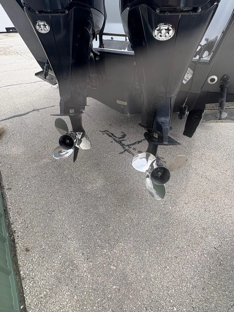 Slide: The Image of 2002 Boston Whaler 27 Vigilant boat with dual outboard motors on a concrete surface. - 14