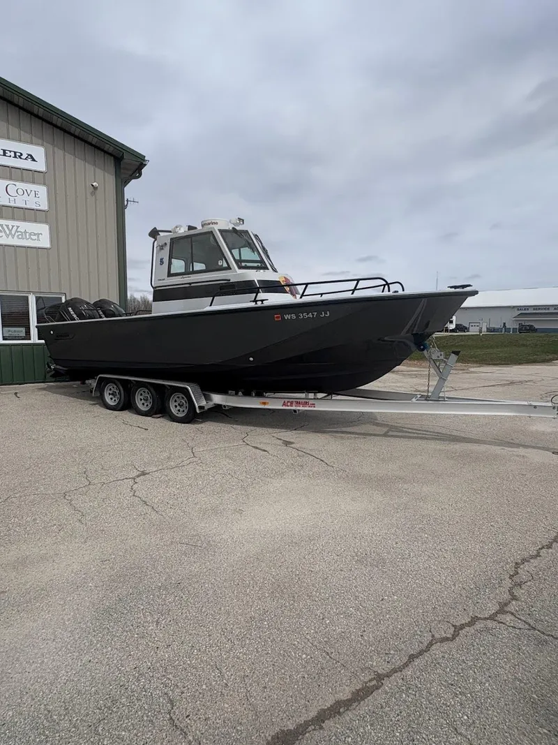 Slide: The Image of 2002 Boston Whaler 27 Vigilant boat on trailer, parked outside a building. - 2