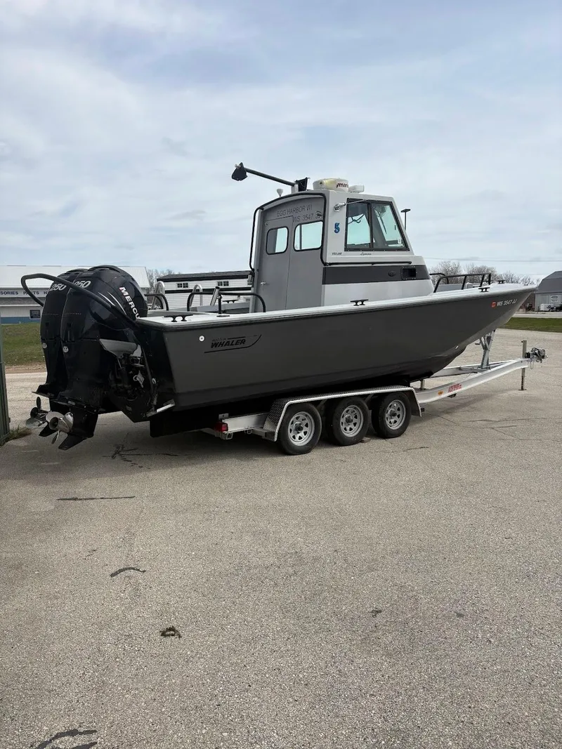 Slide: The Image of 2002 Boston Whaler 27 Vigilant boat on a trailer, parked outdoors. - 3