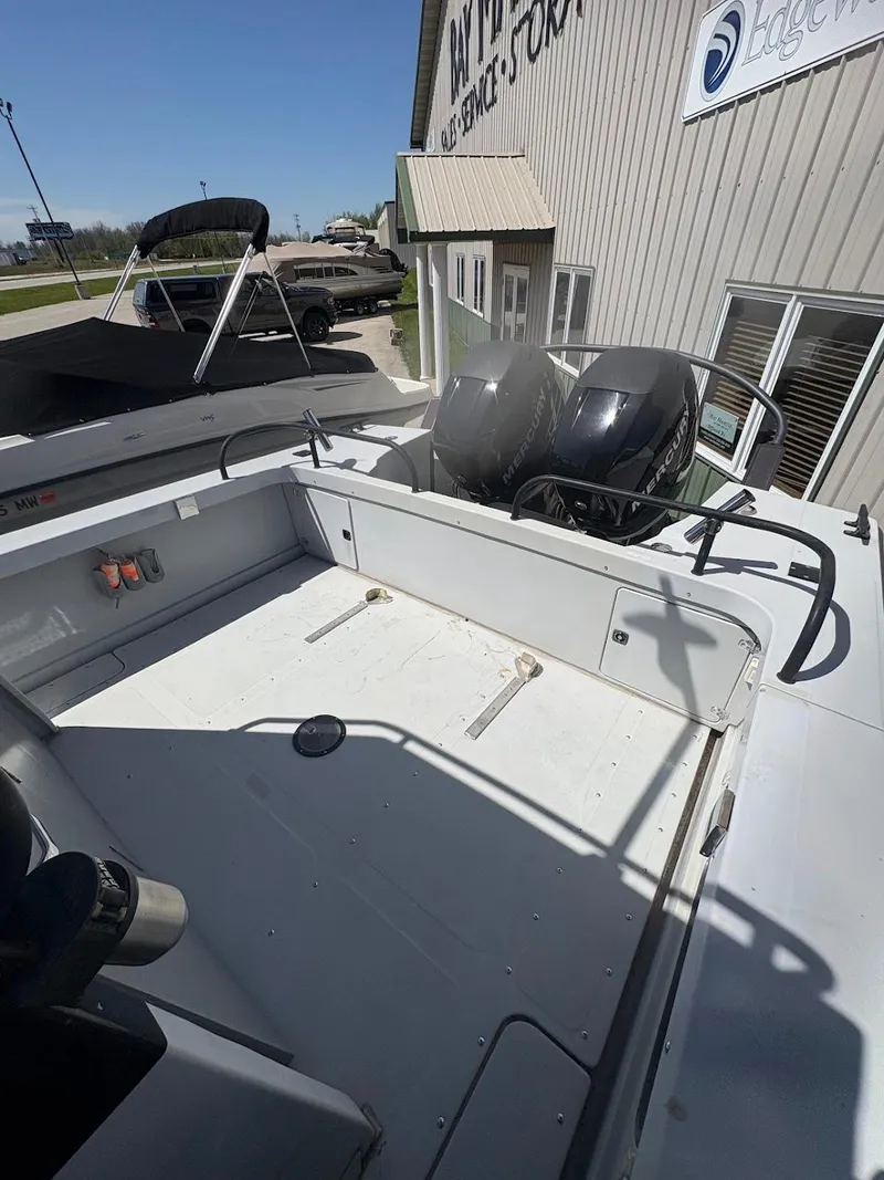 Slide: The Image of 2002 Boston Whaler 27 Vigilant boat with dual engines, docked near a building. - 8