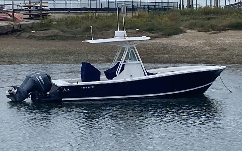 Slide: The Image of 2013 Regulator 26 FS boat with twin engines, anchored in calm waters. - 0