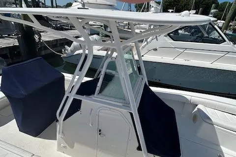 Slide: The Image of 2013 Regulator 26 FS boat with T-top and covered seating at marina. - 11