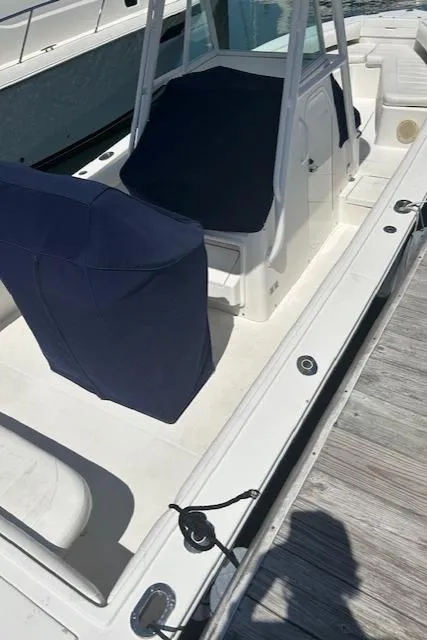 Slide: The Image of 2013 Regulator 26 FS boat with blue covers docked at marina. - 14