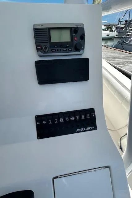 Slide: The Image of Control panel of a 2013 Regulator 26 FS boat with radio and switches. - 16