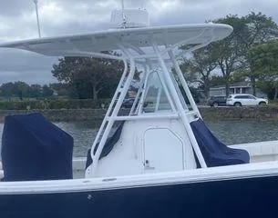 Slide: The Image of 2013 Regulator 26 FS boat with T-top, docked by a scenic waterfront. - 4