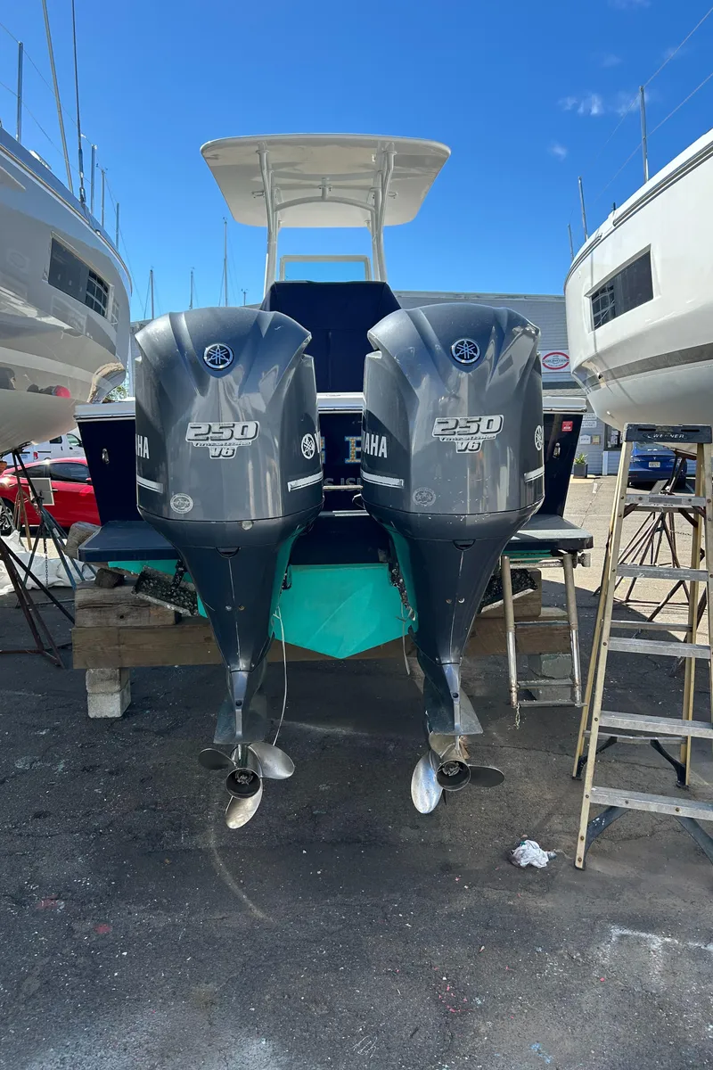 Slide: The Image of 2013 Regulator 26 FS boat with twin Yamaha 250 engines, docked outdoors. - 5