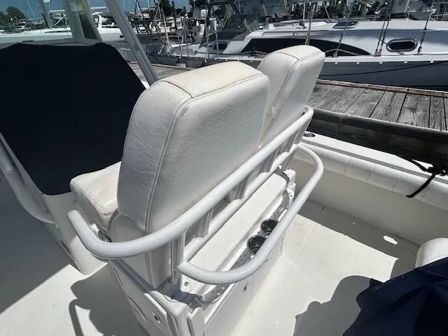 Slide: The Image of 2013 Regulator 26 FS boat with white cushioned seating at a marina. - 7