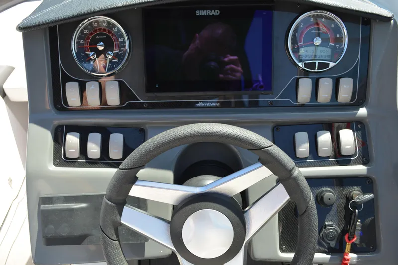 Slide: The Image of 2022 Hurricane SunDeck 2690 OB dashboard with steering wheel and control panel. - 12