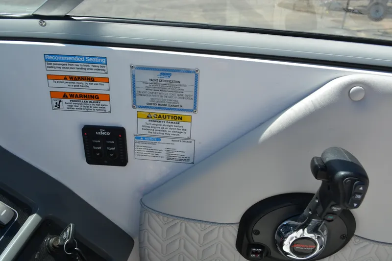 Slide: The Image of Control panel of 2022 Hurricane SunDeck 2690 OB with warning labels and throttle. - 14