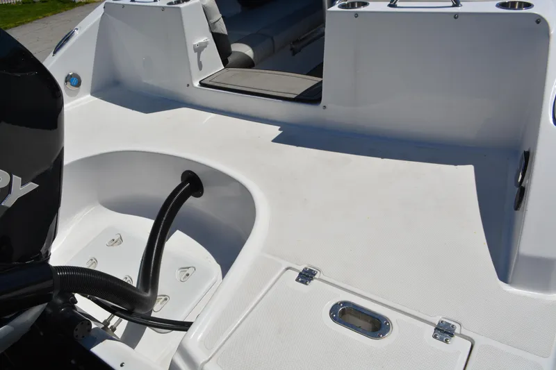 Slide: The Image of 2022 Hurricane SunDeck 2690 OB boat deck with seating and engine compartment. - 15