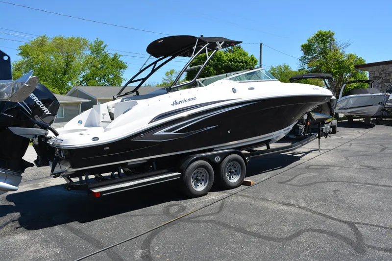 Slide: The Image of 2022 Hurricane SunDeck 2690 OB boat on trailer, parked outdoors. - 2
