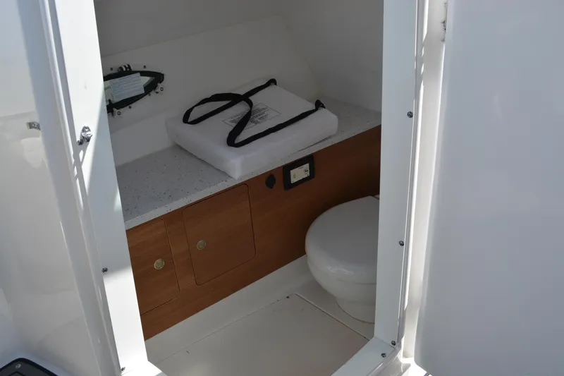 Slide: The Image of 2022 Hurricane SunDeck 2690 OB boat interior with compact bathroom and storage. - 22