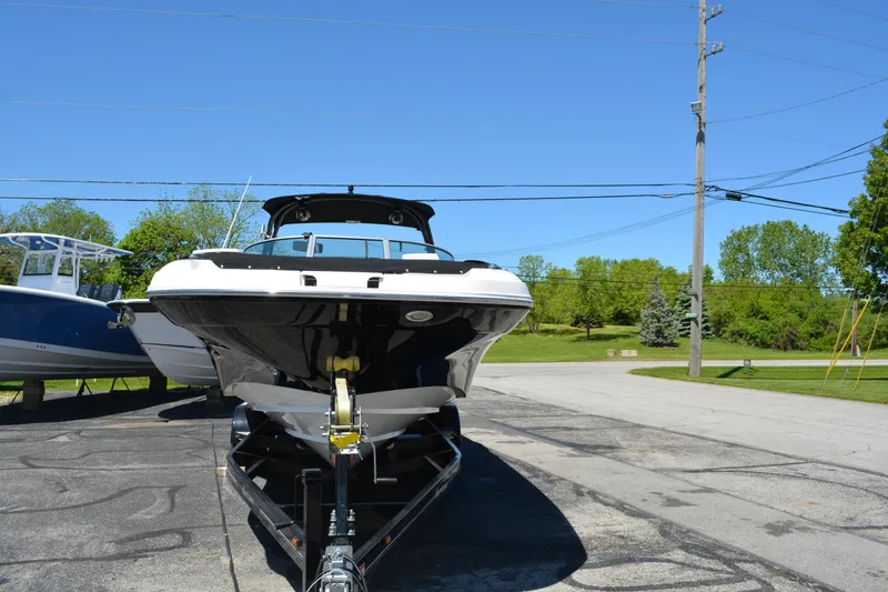 Slide: The Image of 2022 Hurricane SunDeck 2690 OB boat on trailer, parked outdoors under clear blue sky. - 7