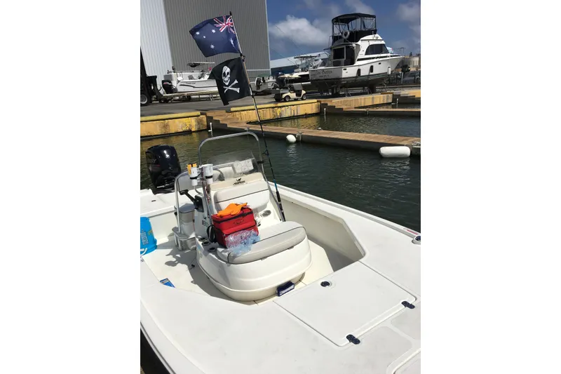 Slide: The Image of 2016 Mako 18 LTS boat docked, featuring pirate and Australian flags. - 10