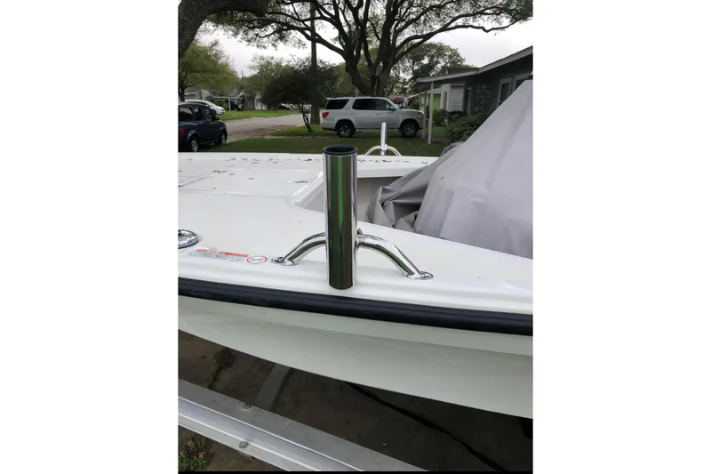 Slide: The Image of 2016 Mako 18 LTS boat with rod holder, parked in residential area. - 6